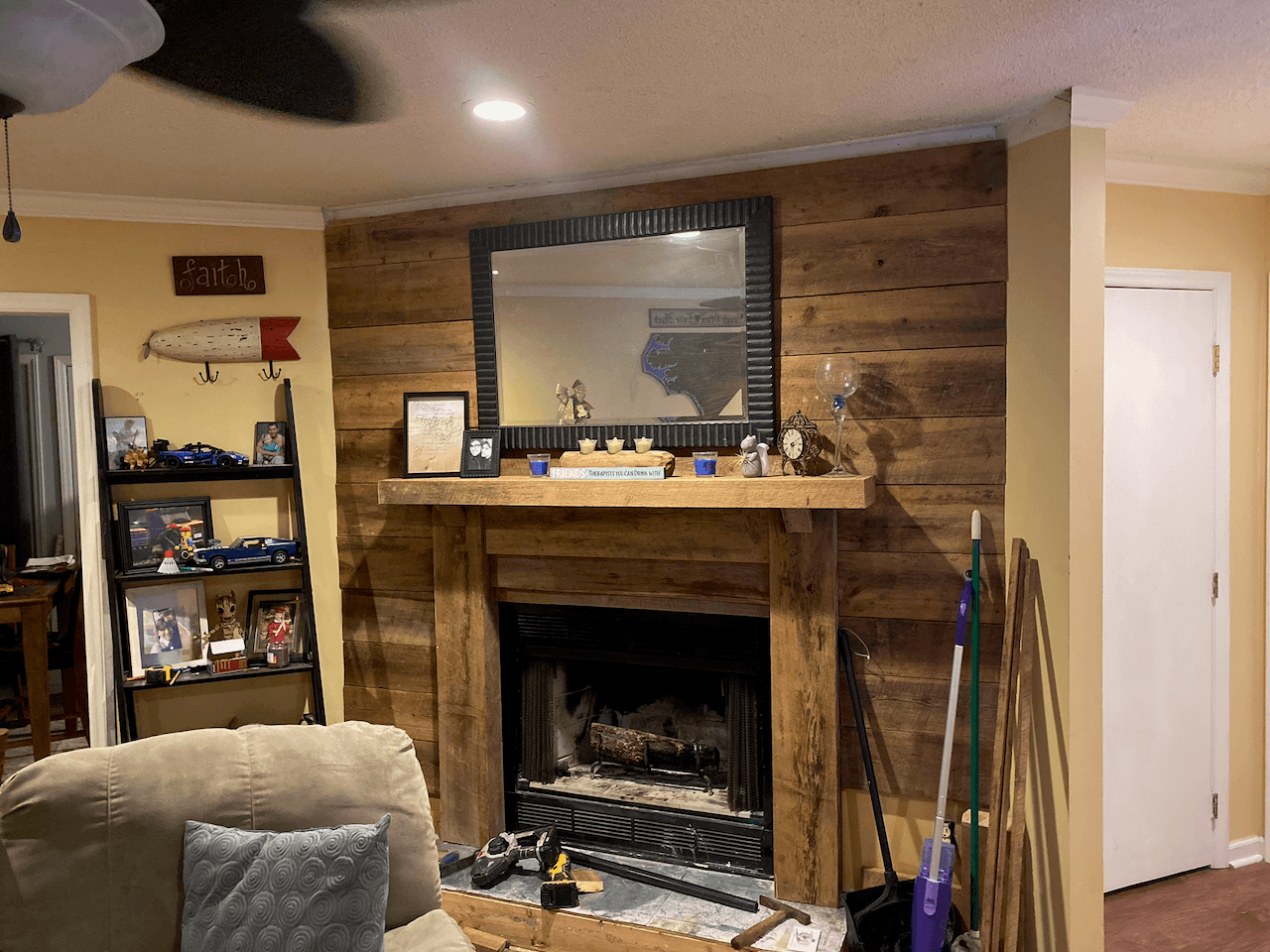 Fireplace with reclaimed wood accent wall and timber mantel